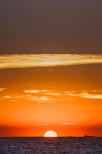 Scenic view of sea against dramatic sky during sunset