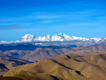 Scenic view of snowcapped mountains against blue sky