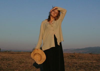 Woman standing on field against sky