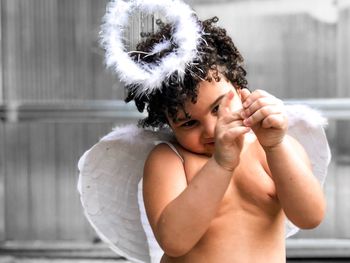 Shirtless boy wearing angel costume