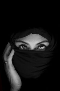 Portrait of beautiful woman against black background