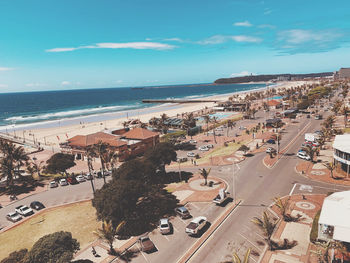 High angle view of city by sea against sky