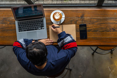 Rear view of man working at table