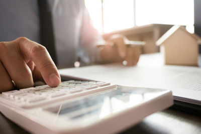 Close-up of man using laptop on table