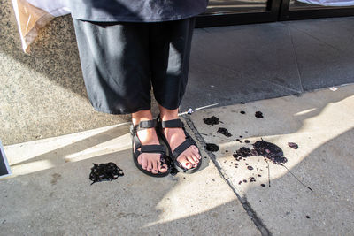 Low section of man standing on street