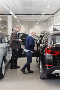 Senior couple examining car in store