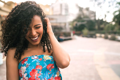 Young woman smiling while standing against blurred background