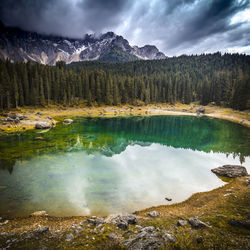 Scenic view of lake by snowcapped mountains against sky