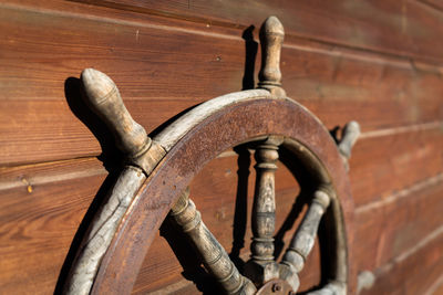 Close-up of old rusty wheel against wall