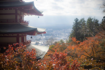 Scenic view of trees by buildings against sky during autumn