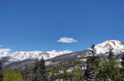 Scenic view of snowcapped mountains against blue sky