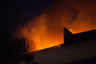 Low angle view of building under fire at night