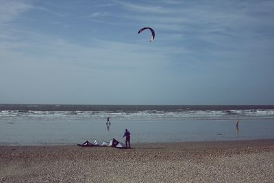 People on beach against sky