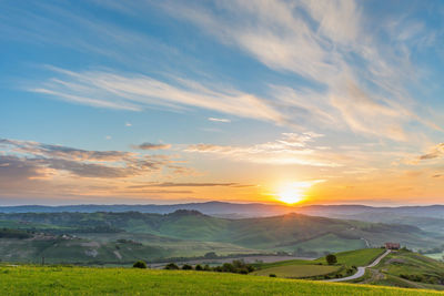 Scenic view of field against sky during sunset