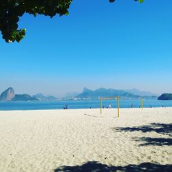 Scenic view of beach against clear blue sky