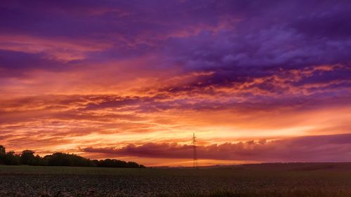 Scenic view of dramatic sky over land during sunset