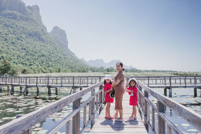 Portrait of woman standing on railing against mountain