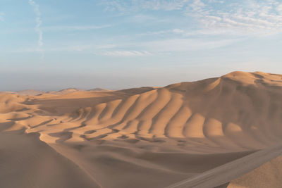 Sand dunes in desert against sky