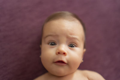 Beautiful baby lying on the sofa with a surprised face