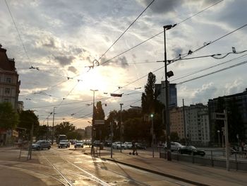 City street and buildings against sky during sunset