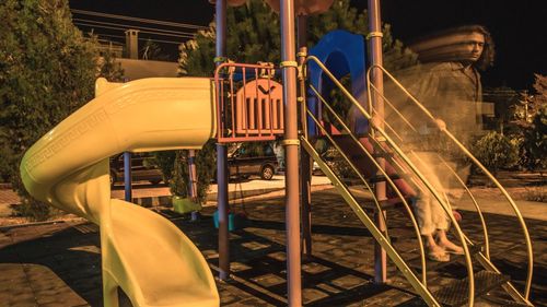 Blurred portrait of man standing on ladder at playground