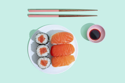 Studio shot of chopsticks, bowl of soy sauce and plate of maki sushi and nigiri