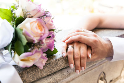 Midsection of couple holding flower bouquet