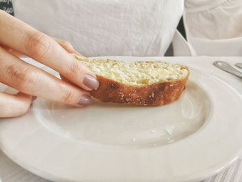 Close-up of hand holding ice cream in plate