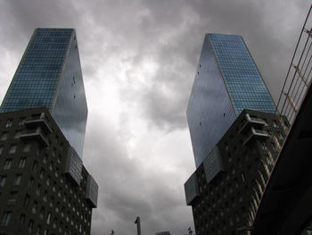 Low angle view of modern building against cloudy sky