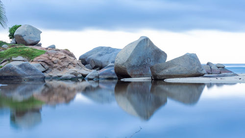 Reflection of rocks in lake against sky