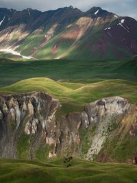 Scenic view of field and mountains against sky