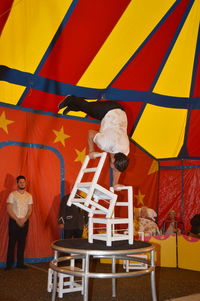 Rear view of man standing on table