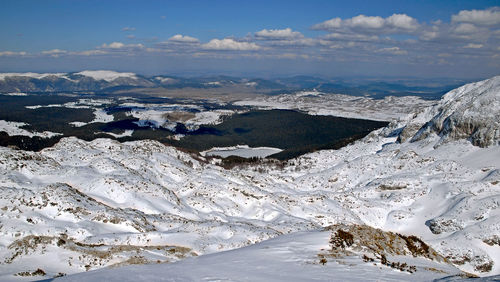 Aerial view of snowcapped mountains against sky