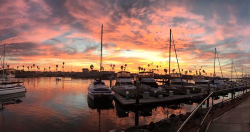 Boats moored in calm sea at sunset