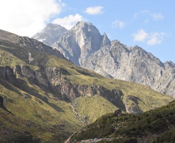 Scenic view of mountain range against cloudy sky