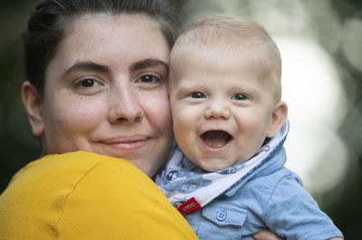 Close-up portrait of smiling mother and baby boy
