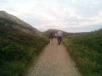 Rear view of man walking on country road