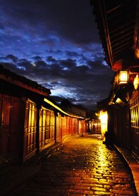 Illuminated walkway against sky at night