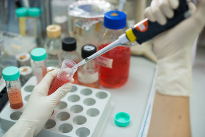 Cropped hands testing chemicals in laboratory