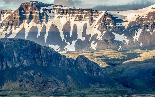 Rugged mountain range dominates the dramatic scenery during a brief icelandic summer