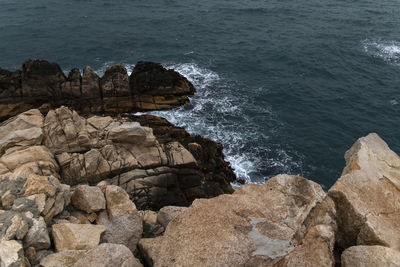 High angle view of rocks at sea shore