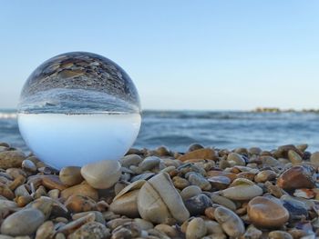 Surface level of stones on beach against clear sky