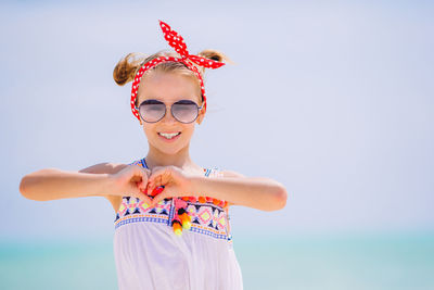 Portrait of woman wearing sunglasses standing against sky