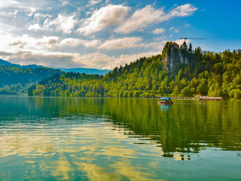 Scenic view of lake by mountain against sky