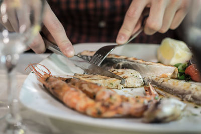 Close-up of hand having food at table