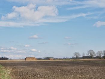 Hay bales on field against sky