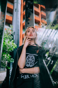 Young woman looking away while standing outdoors