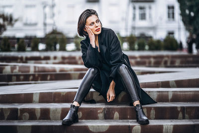 Full length of woman sitting outdoors