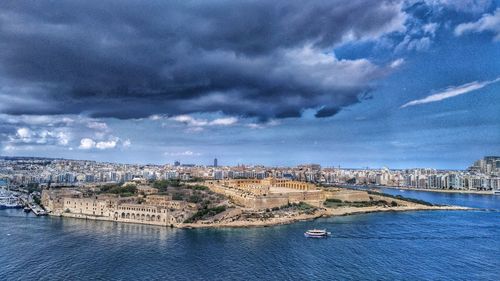 Aerial view of city against cloudy sky