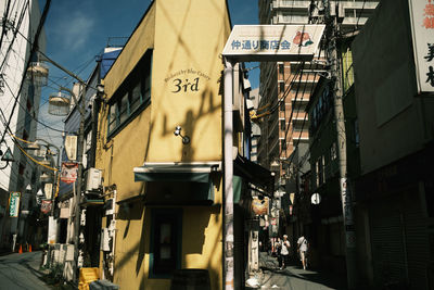 People walking on street amidst buildings in city